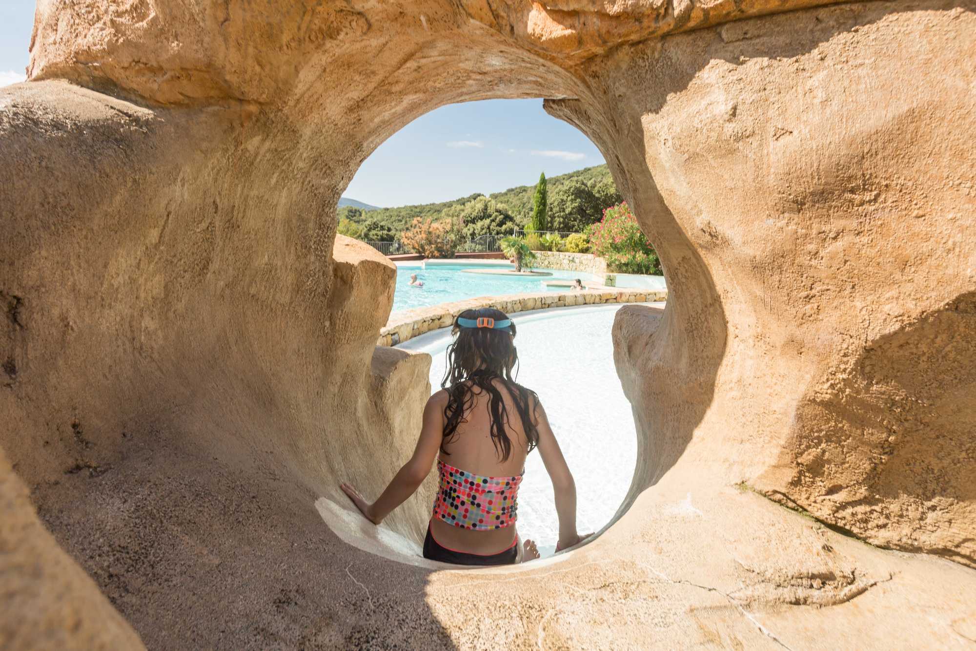 fille dans toboggan de la piscine chauffée du camping en Ardèche